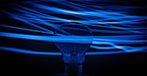 Blue lightbulb on dark background with blue neon swirly lines